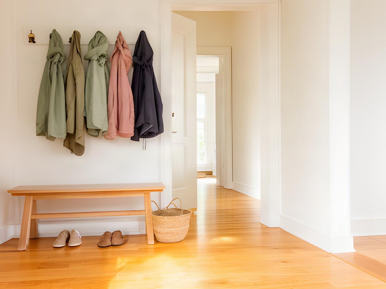 Clean Colchester home entryway with bright floors, wooden bench, and neatly arranged coats